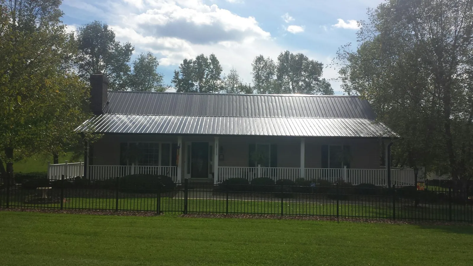 Gray metal roof on a brick ranch with a full width front porch — Gutter Guard Installation work by our crew in Walden