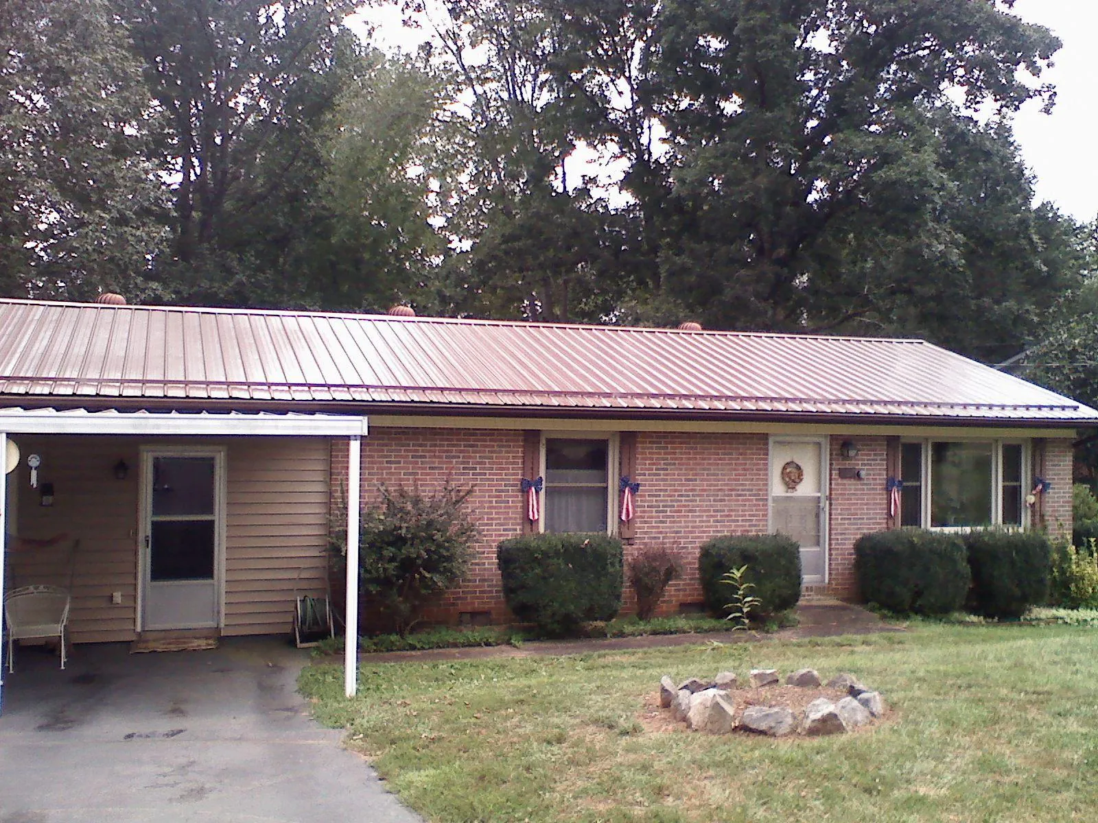Bronze metal roof and carport on a brick ranch home — Roof Repair work by our crew in Walden